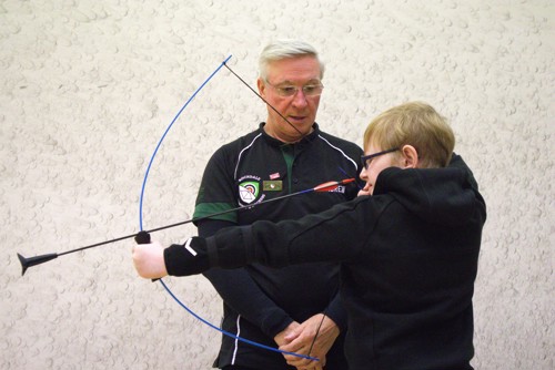 a boy holding a bow and arrow