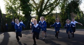 Schoolchildren running around their playground doing The Daily Mile